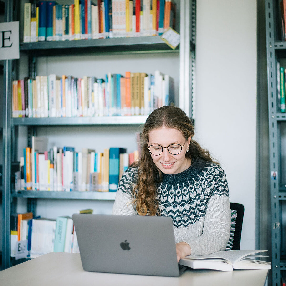 Studentin arbeitet in der Bibliothek