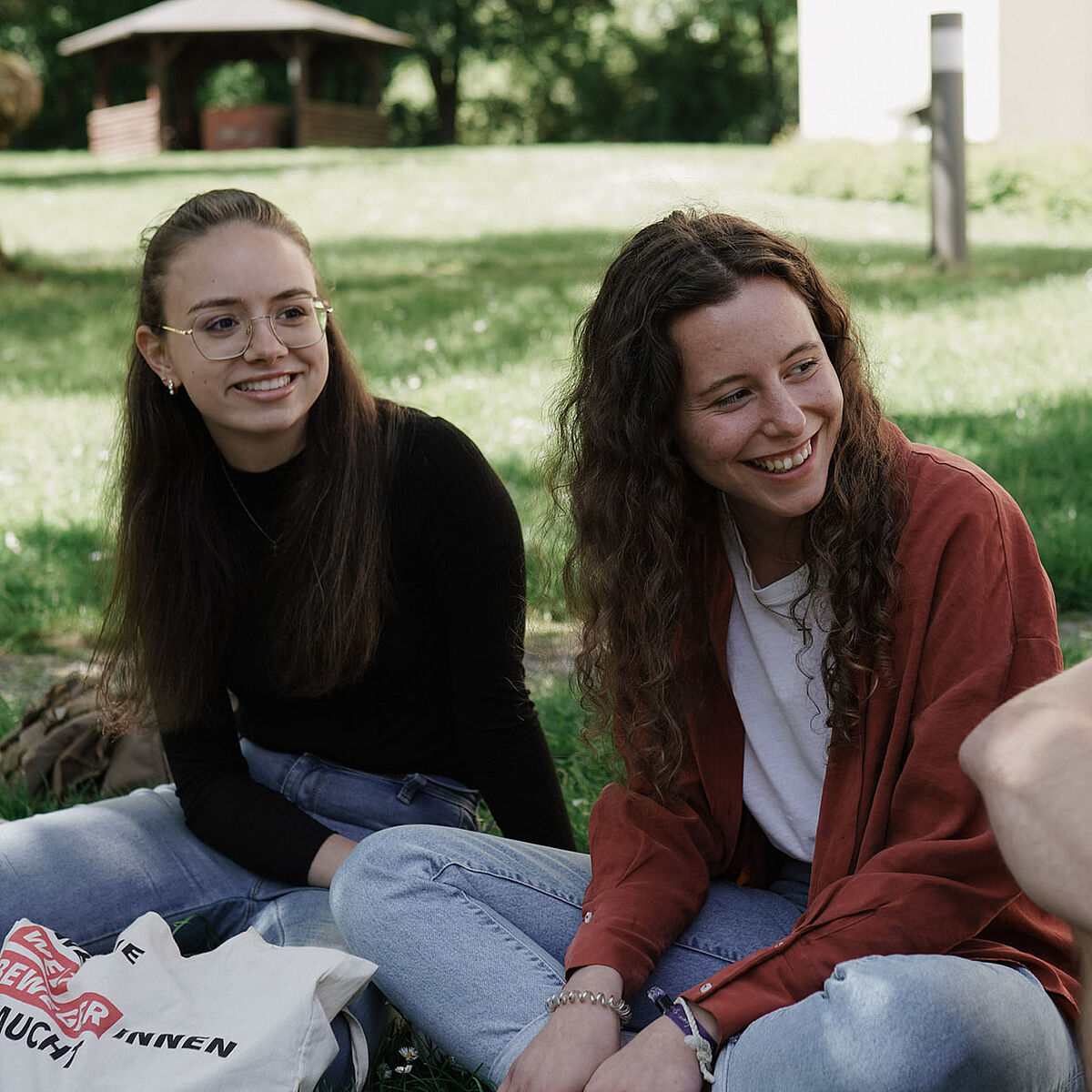Studierende sitzen im Grünen